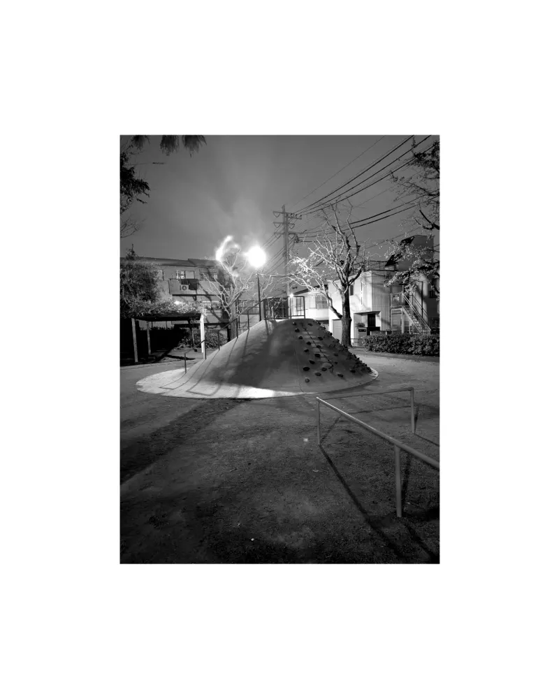 Butte de jeux en béton éclairée la nuit dans un parc